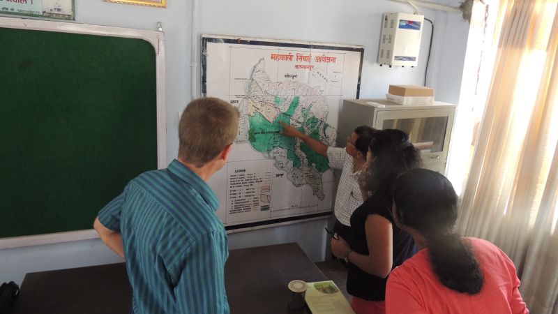 IWMI staff and partners glance at a map of Far West Nepal.